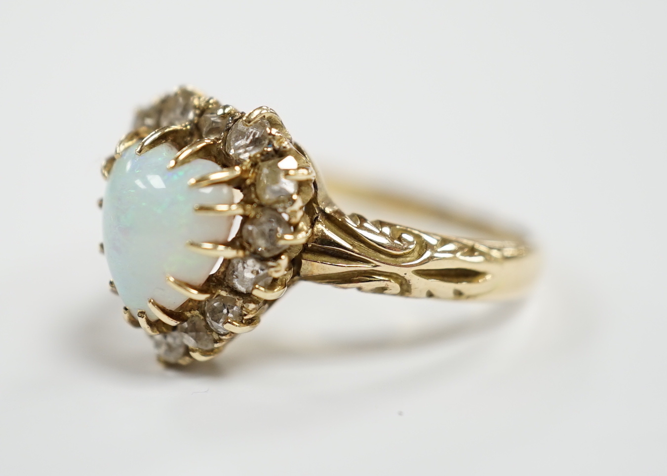 A yellow metal, white opal and diamond set heart shaped cluster ring, size N, gross weight 3.7 grams.